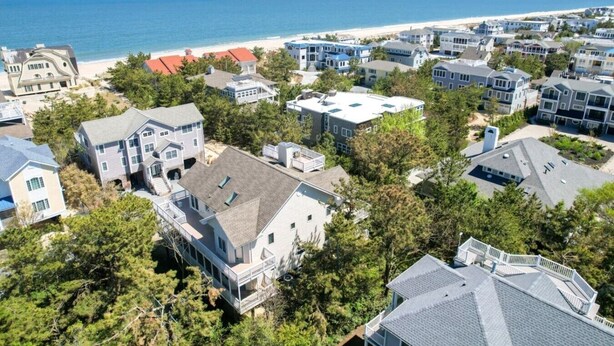 A coastal residential area with houses, a beach, and a clear sky. - Ocean View from Balconies | Steps to Private Beach (Rehoboth Beach)