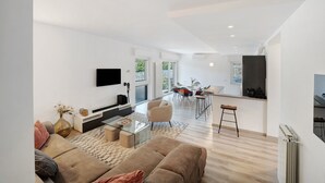 Un espace de vie moderne comprenant un canapé, une table basse et un coin repas avec des chaises et une table.