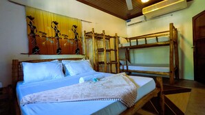 Ein Zimmer mit einem Bett, Etagenbetten, einer Wandteppich und einer Klimaanlage.