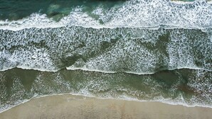 A beach with waves, sand, and water. - 2 Homes • 2 Pools • Sleeps 21 • Across from Beach (Saint Augustine)