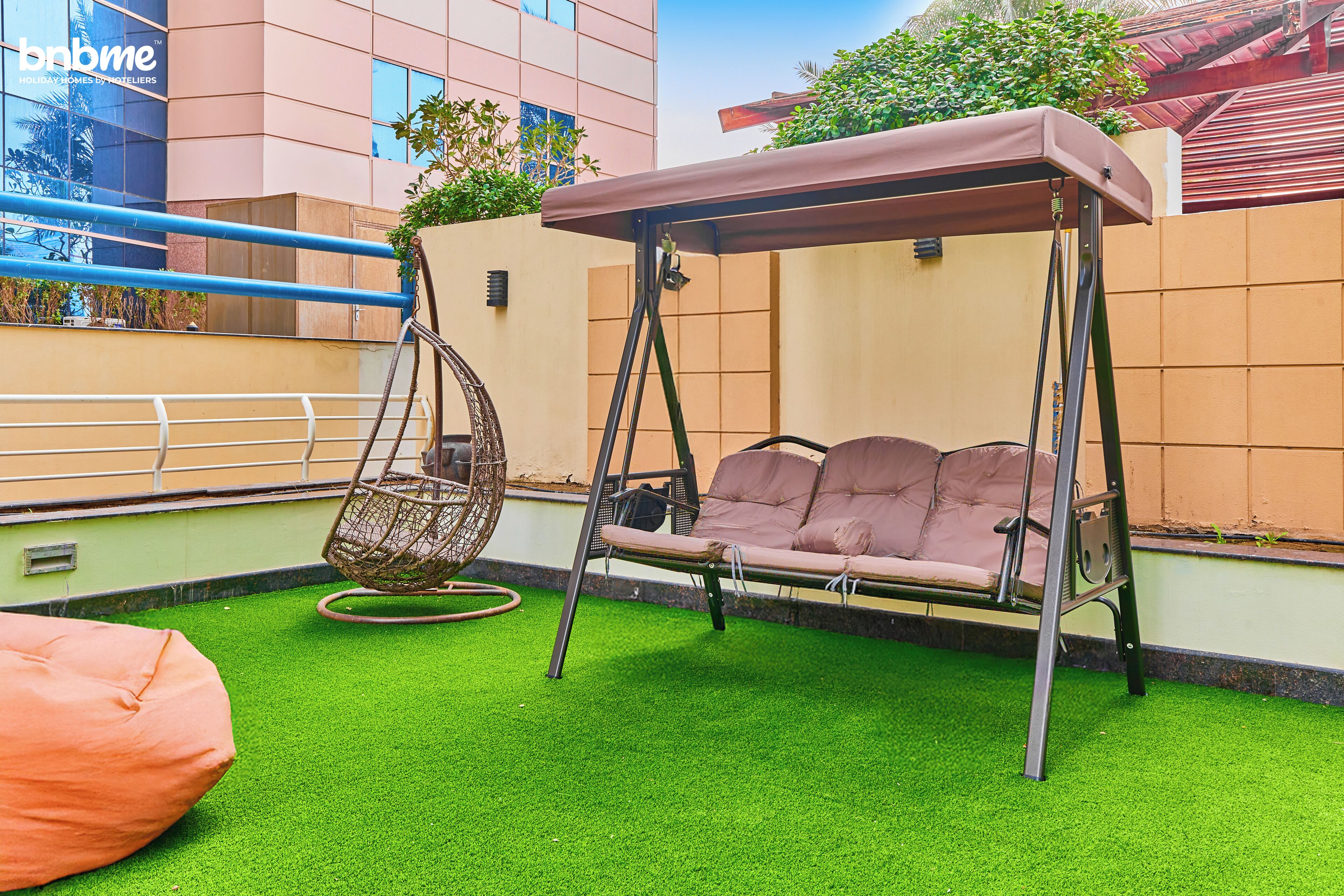 Eine Terrasse mit Schaukel, Hängesessel und Sitzsack.