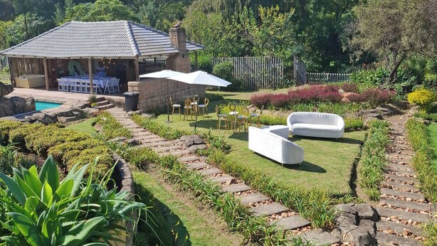 A garden with a patio, outdoor seating, and a pool. - The Address Luxurious (Johannesburg)