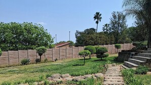 A stone pathway leading up a hill, surrounded by grass and small plants. - The Address Luxurious (Johannesburg)