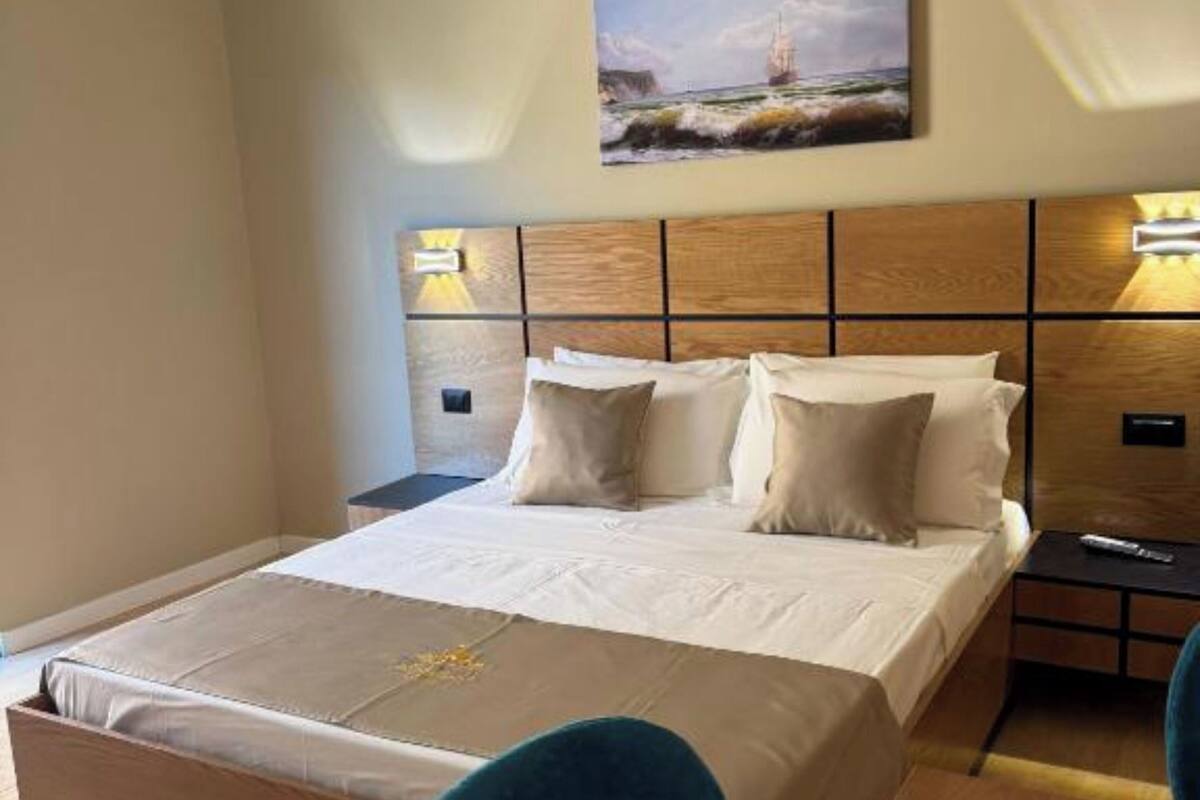 Una habitación de hotel con una cama, un escritorio, una silla y un cuadro en la pared.