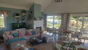 A spacious living room with a sofa, coffee table, and dining area. - Agritourism, family studio. (Ładzin)