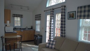 Un espacio habitable pequeño con kitchenette, comedor y sofá.