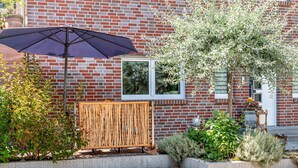 A brick building with a window, a wooden fence, and a potted plant. - Apartment "Weinbergschnecke" with Private Terrace and Wi-Fi (Efringen-Kirchen)
