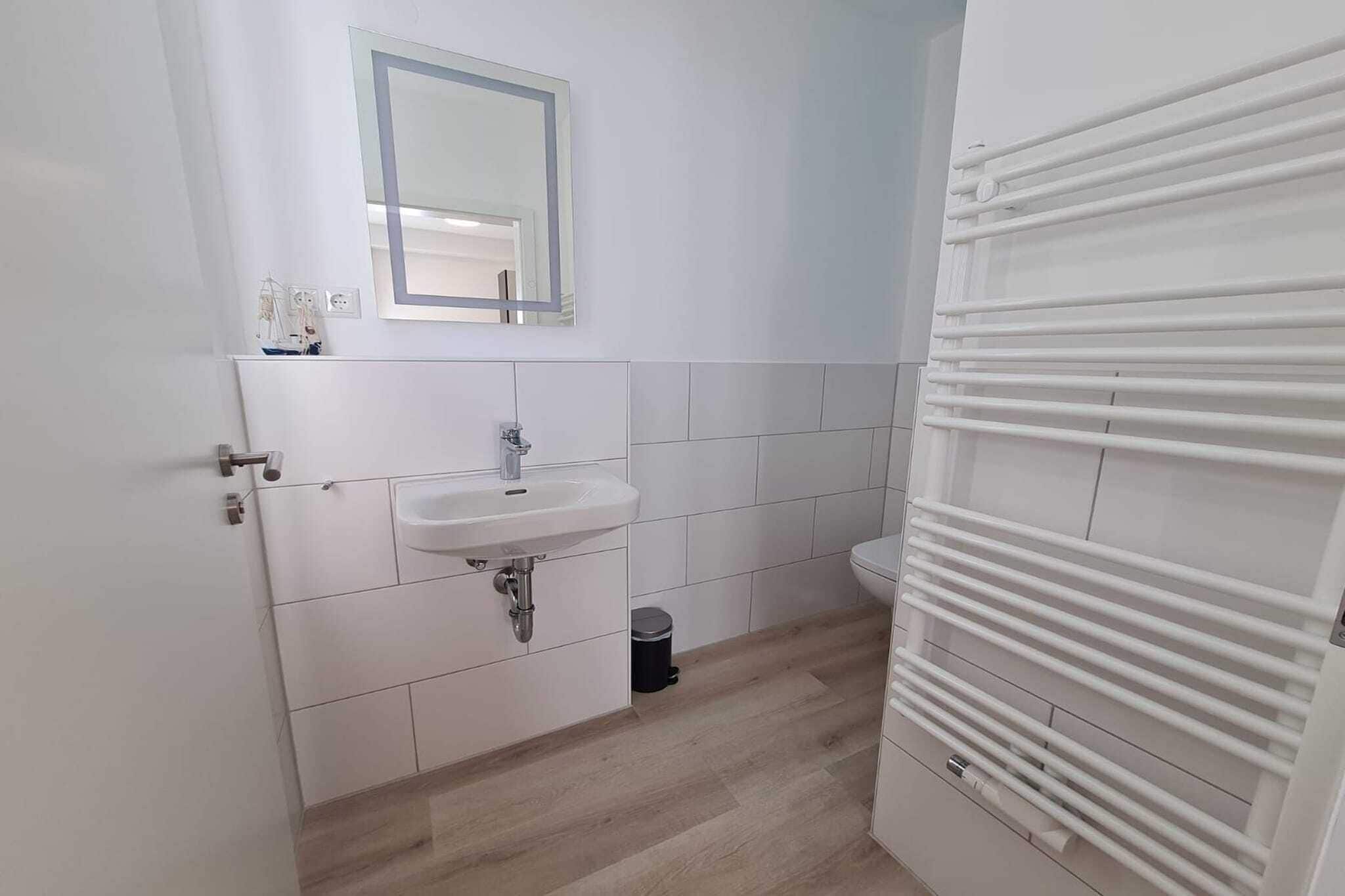 Ein Badezimmer mit Waschbecken, Spiegel und Toilette.
