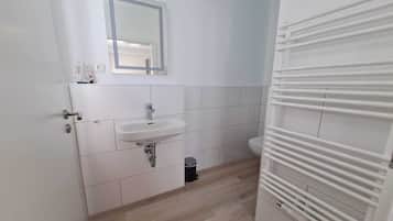 Ein Badezimmer mit Waschbecken, Spiegel und Toilette.