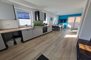 Cafetera o tetera, frigorífico, microondas y placa de cocina