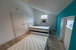 Un dormitorio pequeño con cama, ventana y puerta.