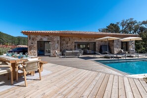 A stone building with a pool, outdoor seating, and a wooden deck. - La Villa Frassolo - Belle terrasse avec piscine (Lecci)