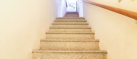Un escalier avec une rampe menant à un palier.
