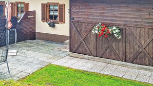 Ein rustikales Gebäude mit Holzläden, einem Metalldach und einem Blumenkasten an der Wand.