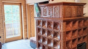 Ein Holzhäuschen im Inneren mit einem großen Holzschrank, einer Schiebetür aus Glas und einer Bank.