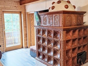 A wooden cabin interior with a large wooden cabinet, a sliding glass door, and a bench. - Ferienwohnung Belan by Interhome (Klippitztörl)