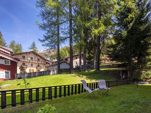 Un quartiere residenziale con case, un prato e una recinzione nera.