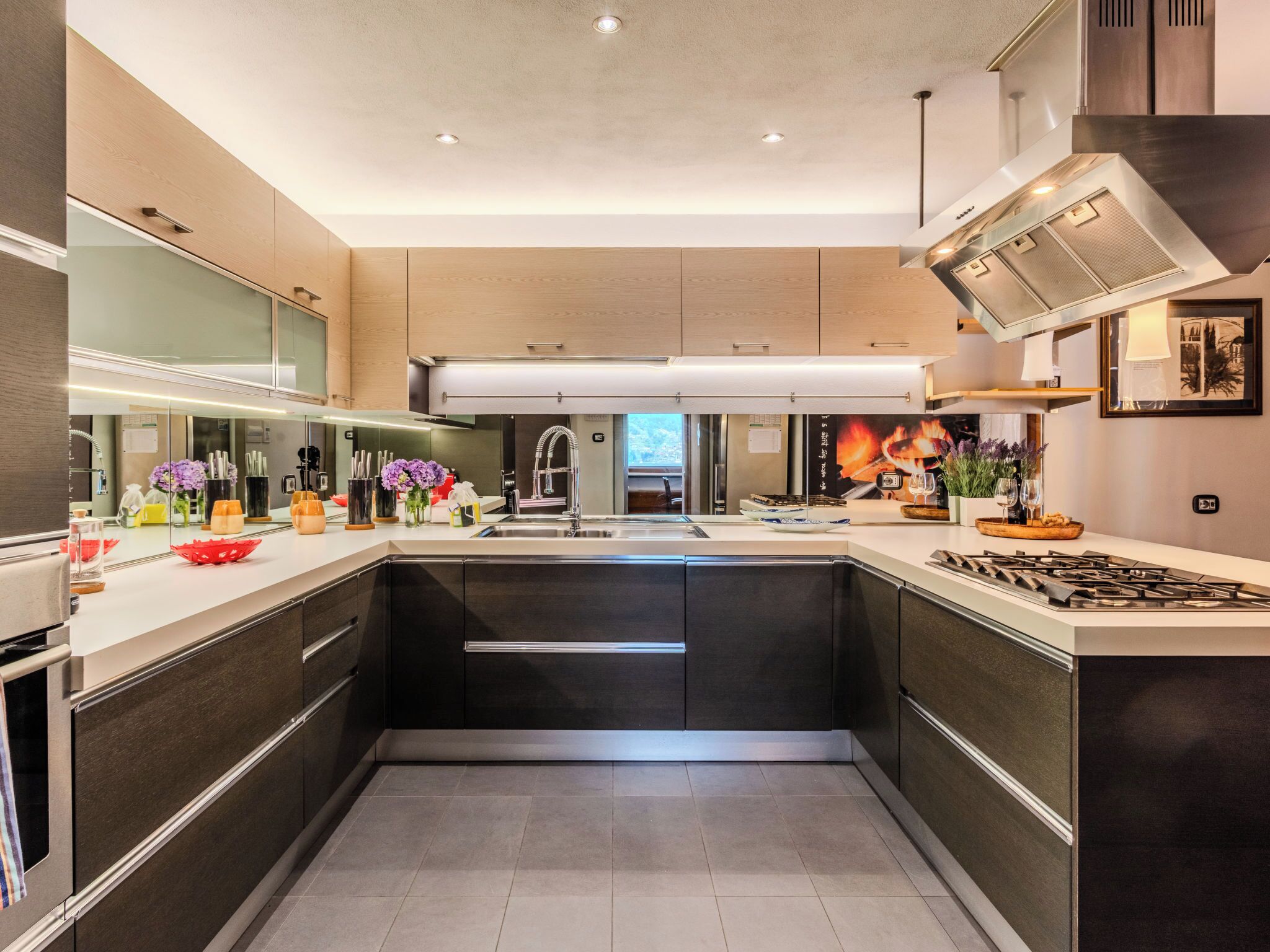 Una cocina moderna con una isla central, electrodomésticos de acero inoxidable y un ventanal que proporciona luz natural.