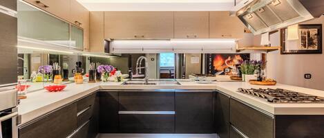 Una cocina moderna con una isla central, electrodomésticos de acero inoxidable y un ventanal que proporciona luz natural.