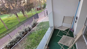A balcony with a green artificial turf, a folding chair, a broom, and a bucket. - Escale Zen & Loggia: 5 min from the train station (Direct Paris) + Parking (Évry-Courcouronnes)