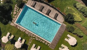 Una piscina al aire libre, sombrillas, tumbonas