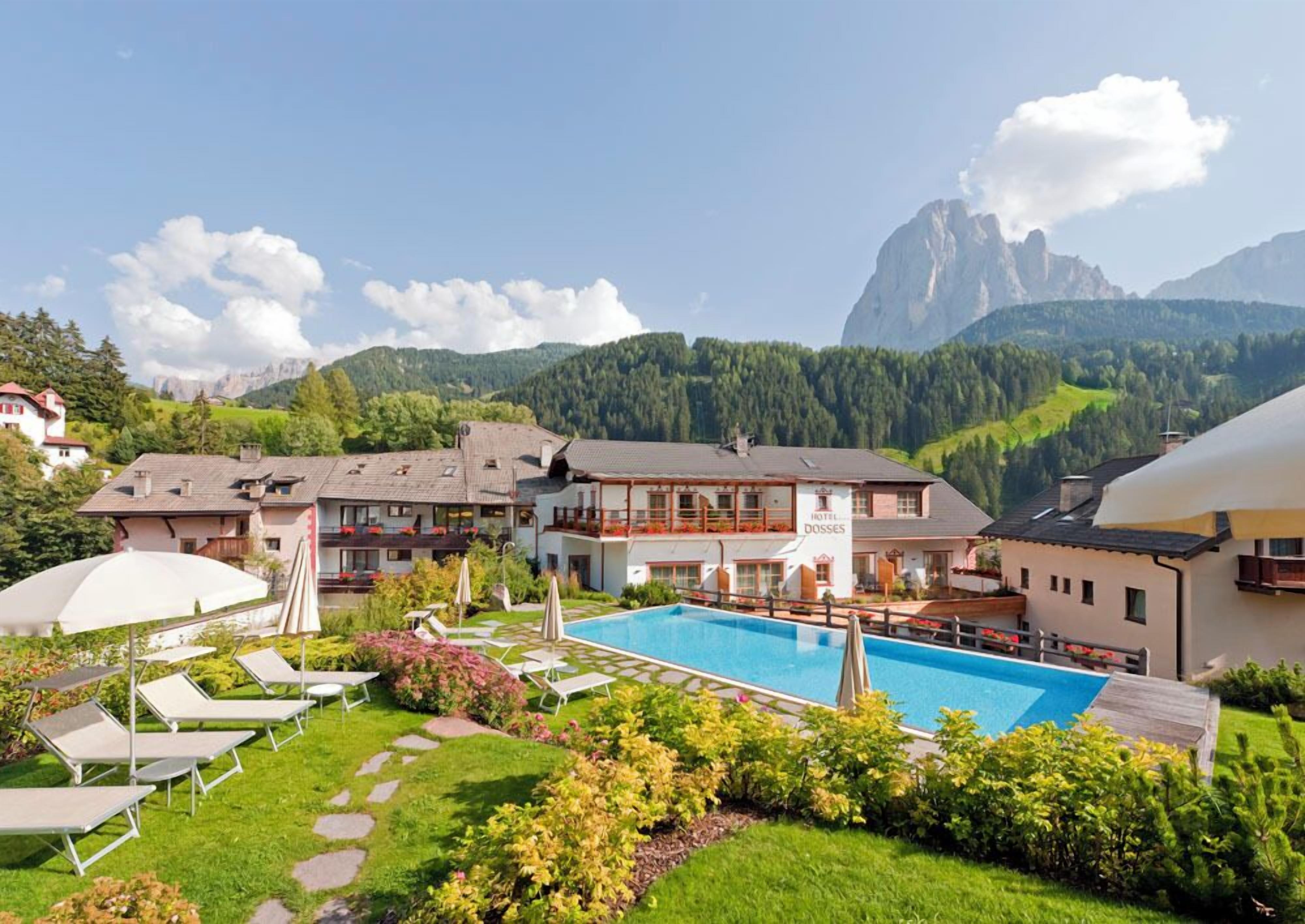Un hôtel doté d’une piscine, d’un espace extérieur aménagé et offrant une vue sur les montagnes.