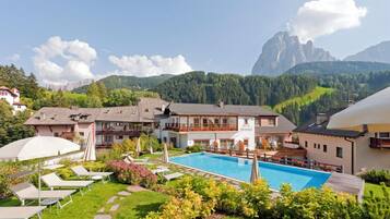 Un hôtel doté d’une piscine, d’un espace extérieur aménagé et offrant une vue sur les montagnes.