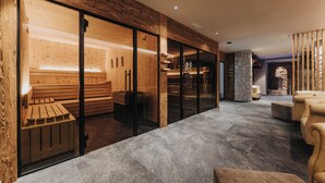 Um interior moderno com sauna, paredes de madeira e lareira de pedra.