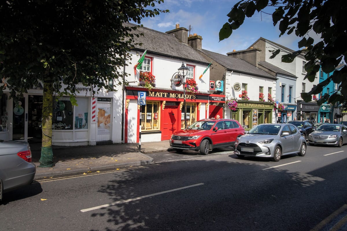 A street with a pub named 'Matt Molloy's' and a pharmacy across the road.