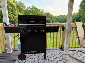 Ein Charbroil-Grill auf einer Holzterrasse mit Blick auf eine grüne Landschaft.
