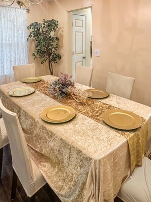 A dining table with a textured tablecloth, gold plates, and a centerpiece. - Penny Cove - Stone Mountain (Stone Mountain)