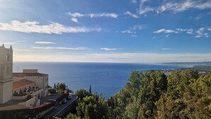 A coastal view with a church, a road, and dense greenery. - House Awaya Taormina Cathedral - Villa (Taormina)