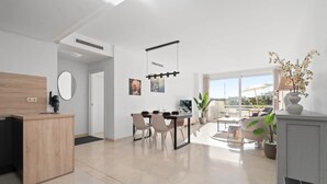 En moderne opholdsstue med et køkken, spiseplads og en balkon med udsigt.