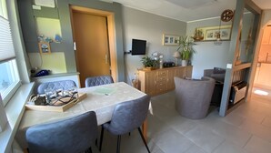 A dining area with a table, chairs, and a cabinet. - Holiday Home in Dranske (Dranske)