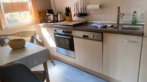 A kitchen with a stove, oven, sink, and various utensils. - Holiday Home in Dranske (Dranske)