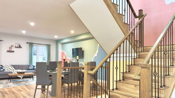 Ein modernes Wohnzimmer mit einer Holztreppe, einem Essbereich und einem Sofa.