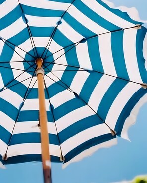 Un primo piano di un ombrellone da spiaggia a righe.