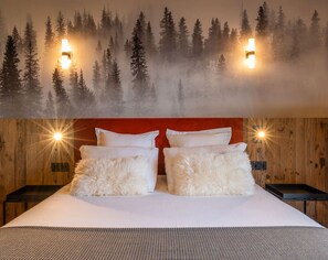 Un lit avec une literie blanche, deux oreillers moelleux et une tête de lit rouge.