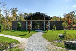 Un bâtiment doté d’une entrée couverte, de murs en pierre et d’un chemin de gravier menant à l’entrée.