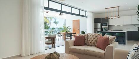 A modern living room with a sofa, coffee table, and dining area.
