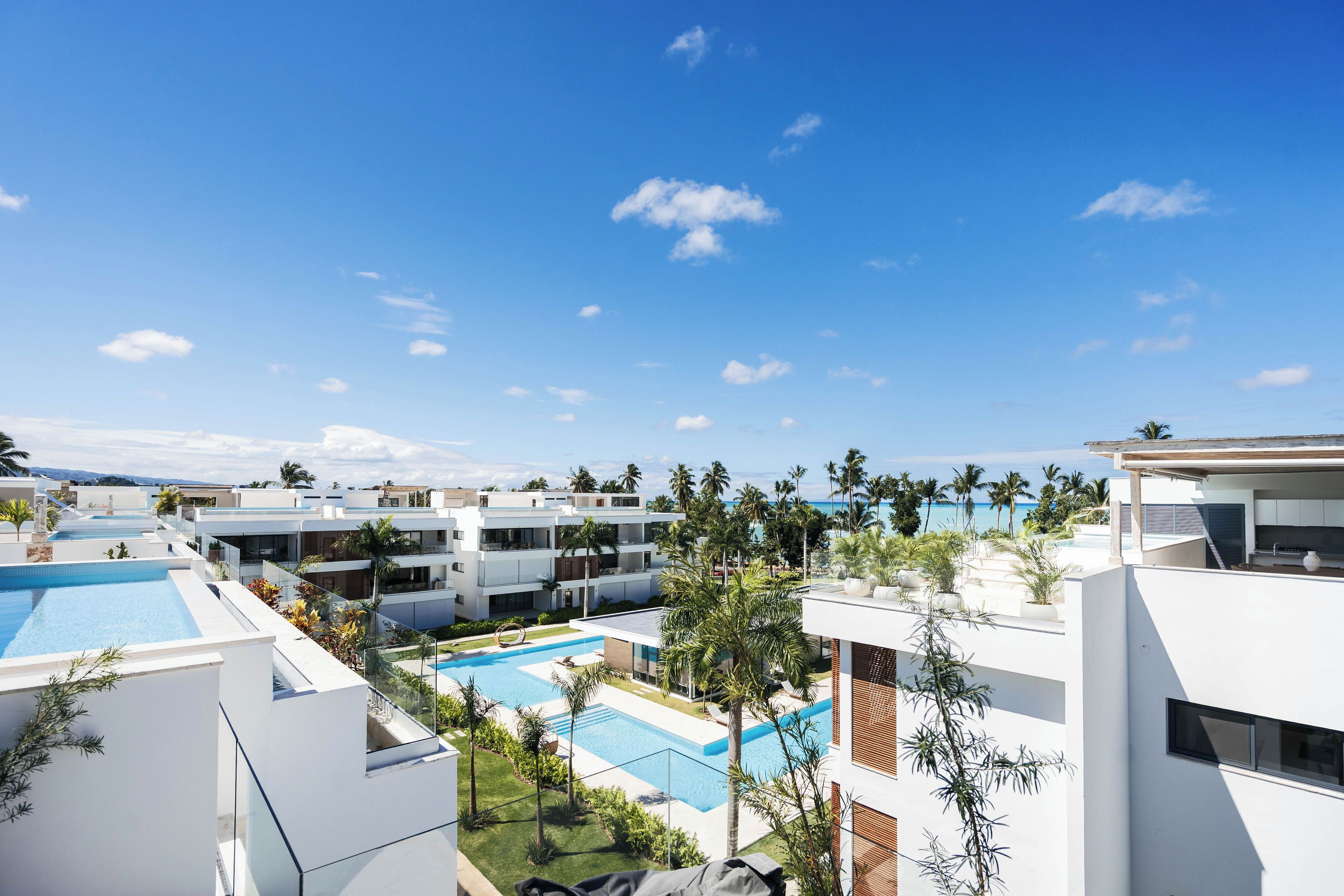Un resort con diverse piscine, architettura moderna e palme.