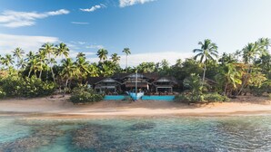 A beachfront resort with multiple buildings, a swimming pool, and palm trees. - Sol de Arena Beachfront Condos (Las Terrenas)