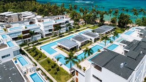 A resort with multiple swimming pools, modern architecture, and a view of the ocean. - Sol de Arena Beachfront Condos (Las Terrenas)