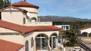 A building with a tiled roof, a satellite dish, and a pool.