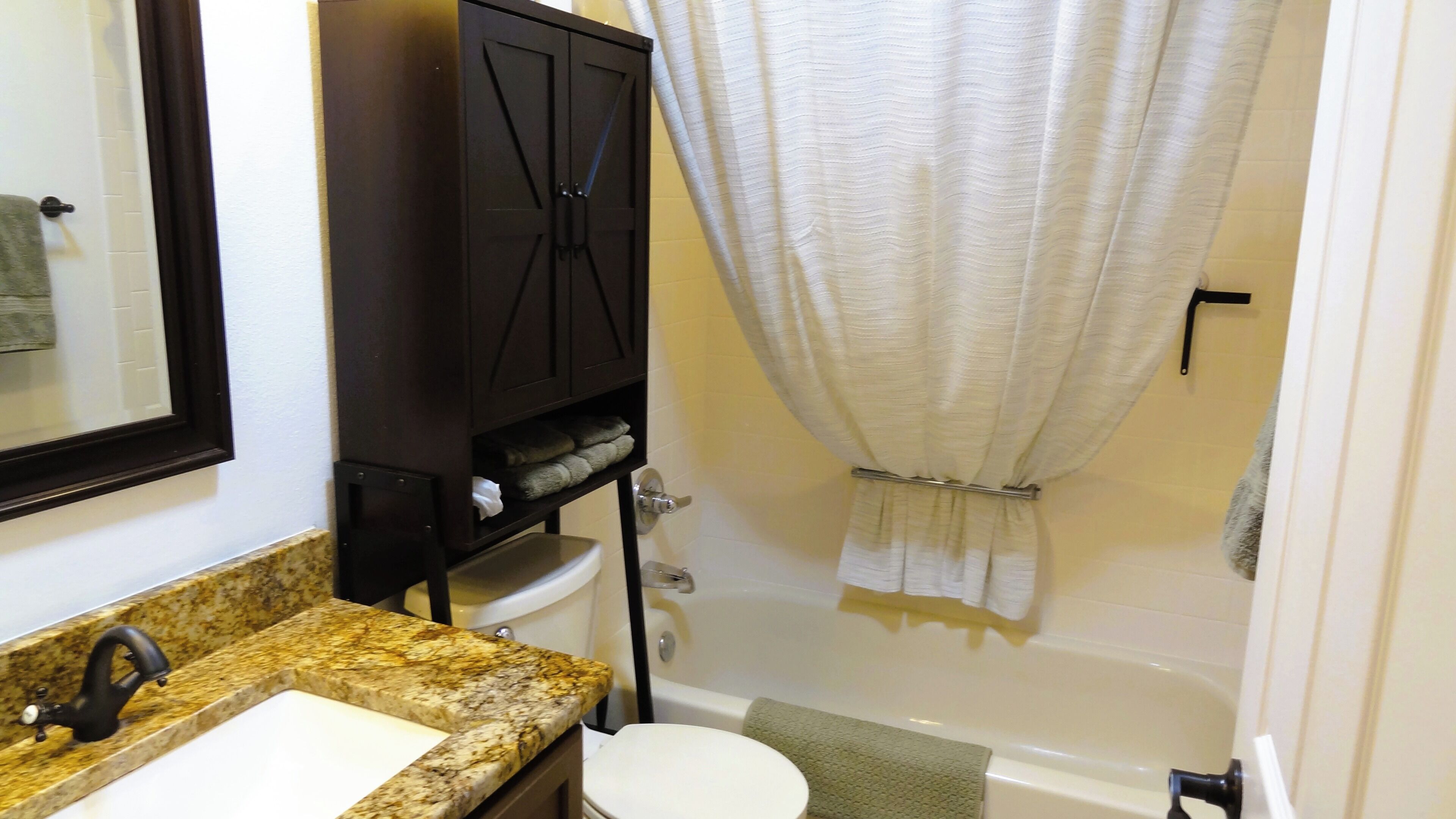 Ein Badezimmer mit Waschbecken, Toilette, Badewanne und Handtuchhalter.