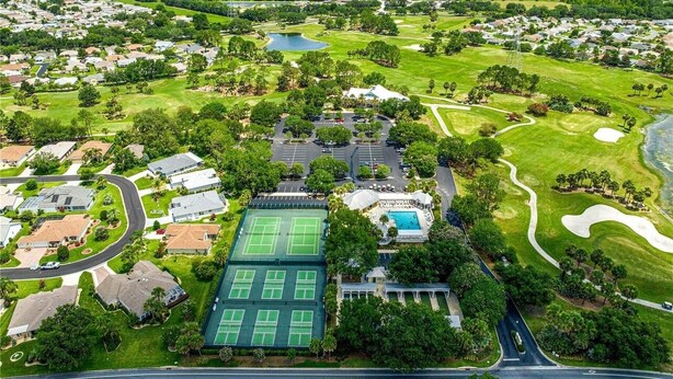 Eine Vogelperspektive eines Wohngebiets mit Häusern, einem Tennisplatz, einem Schwimmbad und einem Golfplatz.