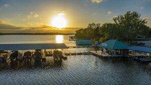 A marina with docked boats, a covered boat ramp, and a small building with a sign. - Grand Lake Casino Lodge (Grove)