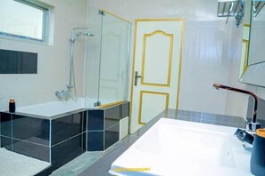 Suite Deluxe, vistas a la ciudad | Baño | Ducha, toallas, jabón y papel higiénico
