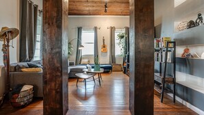 A spacious living area with a wooden floor, a sofa, a coffee table, and a bookshelf. - Casa Azul. Ideal for groups of 8+. 5 bdr / 4 bath (San Antonio)