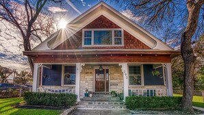 A two-story house with a front porch, a brick chimney, and a well-maintained lawn. - Casa Azul. Ideal for groups of 8+. 5 bdr / 4 bath (San Antonio)